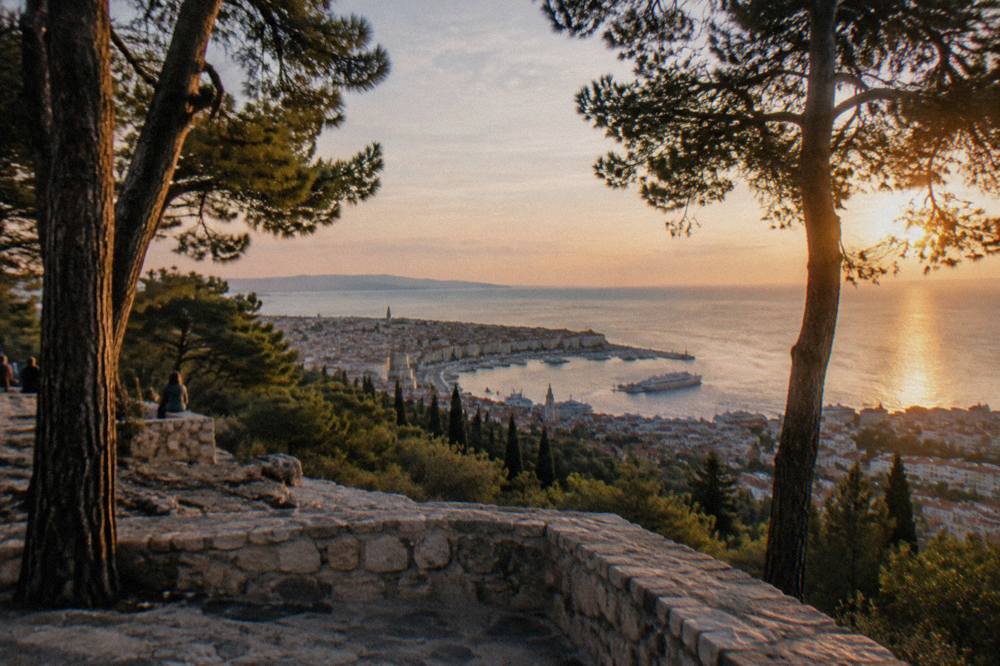 Pine trees and a stone viewpoint on Marjan hill overlooking the sea at golden hour