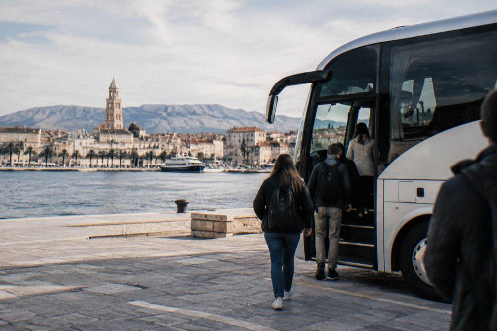 An intercity coach parked at a seaside station with passengers boarding