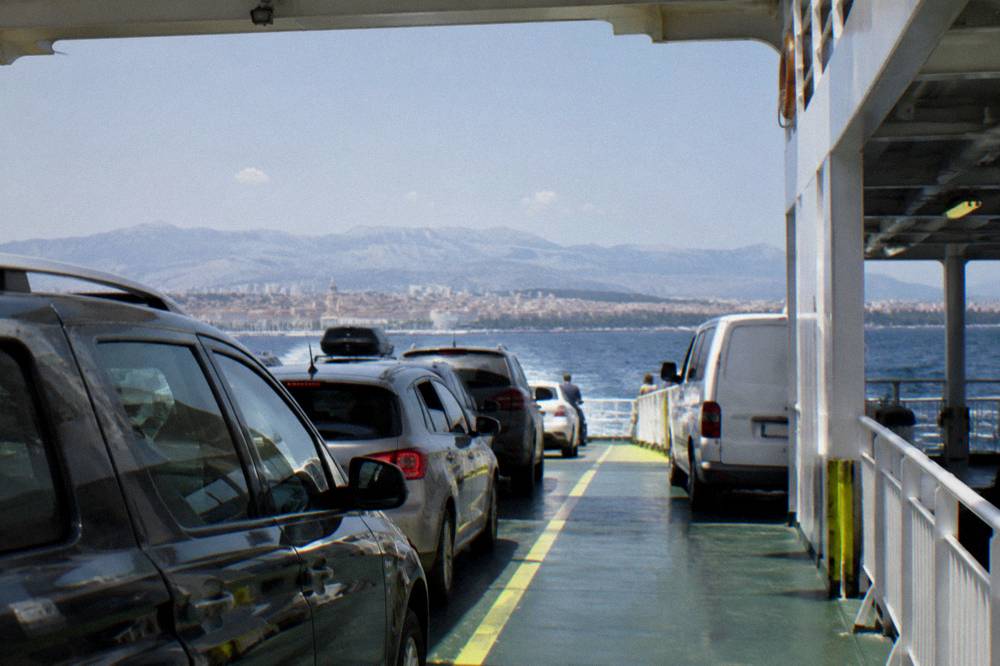 Vehicles lined up on the open car deck of a ferry at sea