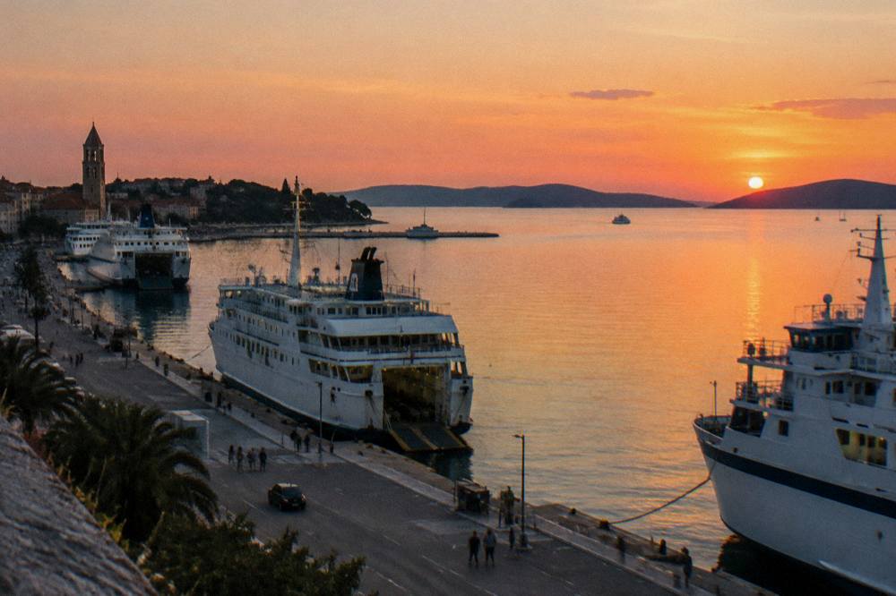 A wide view of a busy harbour with ferries moored along the quayside at dusk