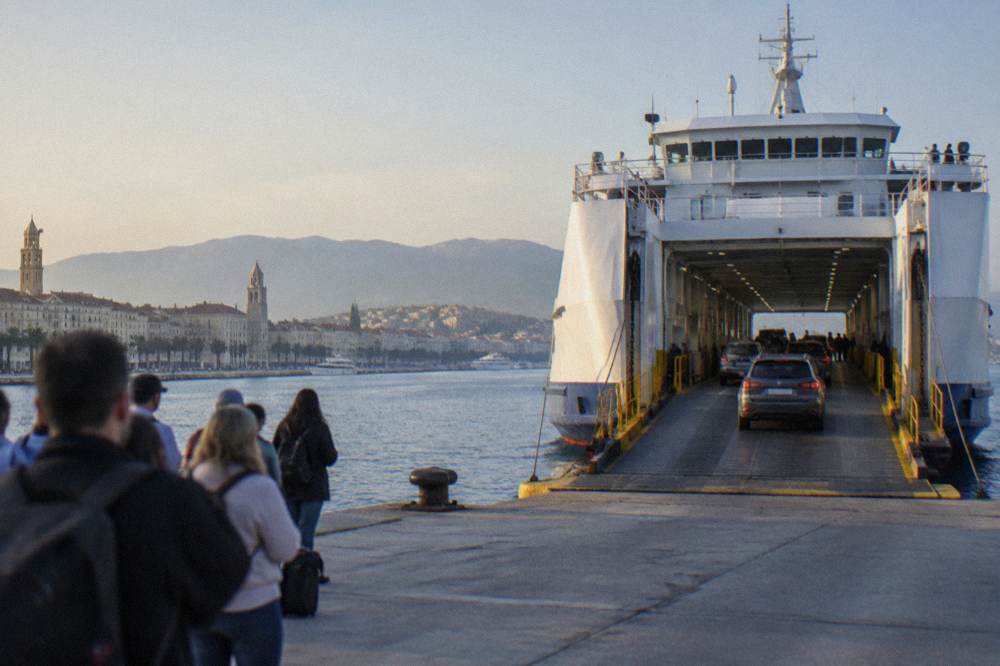 A car ferry loading vehicles at a Split berth with passengers waiting at the gangway