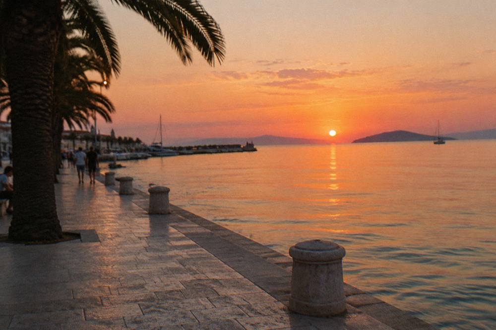 Sunset light on a stone waterfront promenade facing open sea