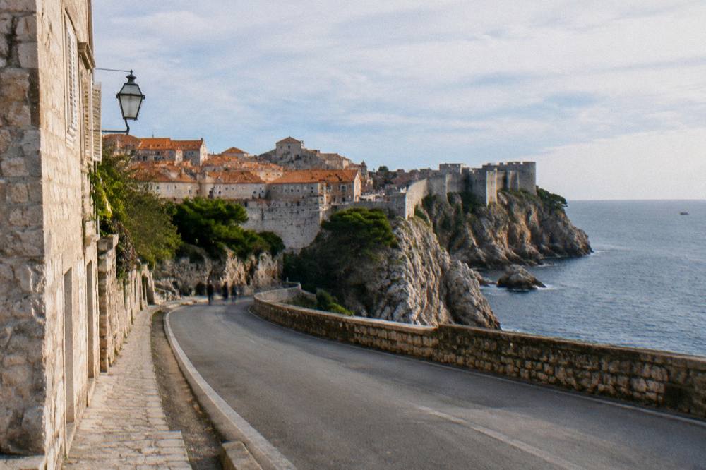 Coastal road curving along a steep Adriatic shoreline with the sea beyond