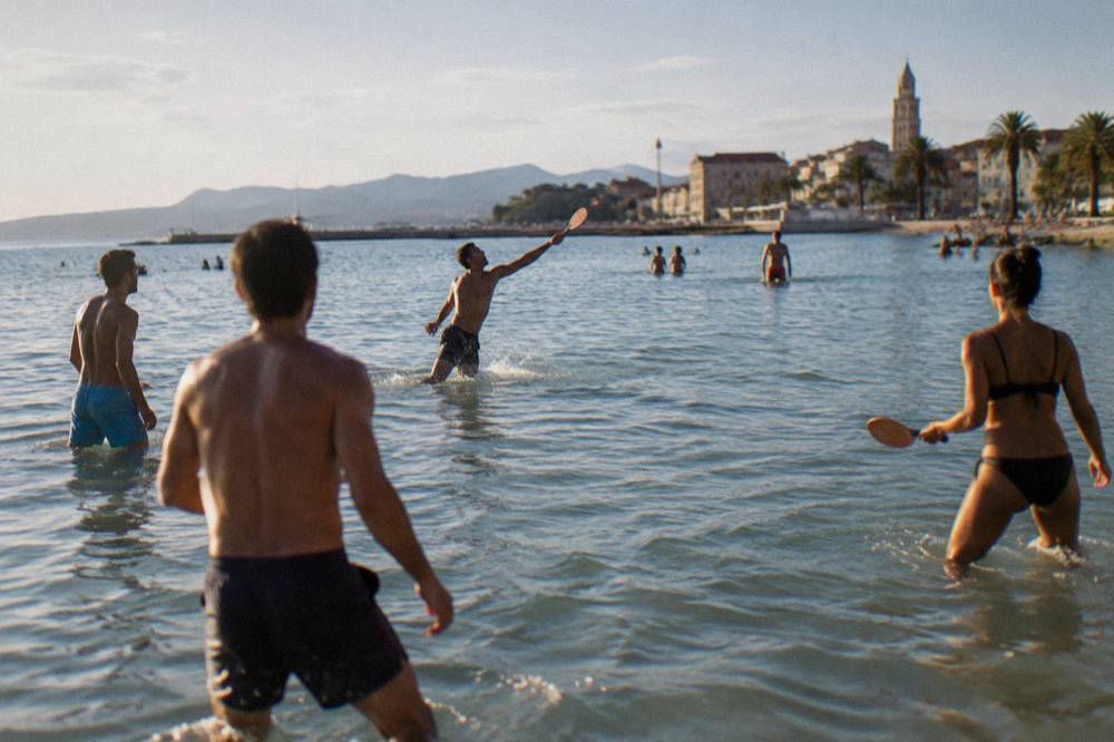 People playing picigin in shallow water at Bačvice beach in Split