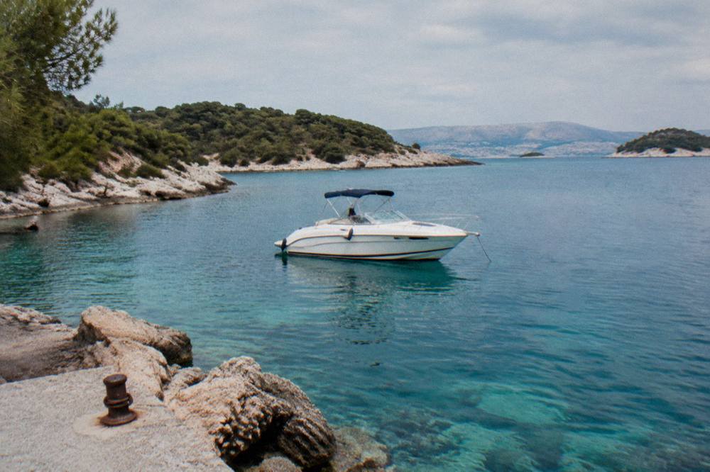Speedboat anchored in a turquoise cove between Dalmatian islands