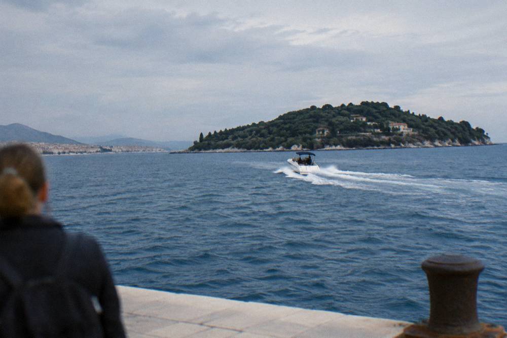 A speedboat cutting across open blue water toward an island off the Split coast