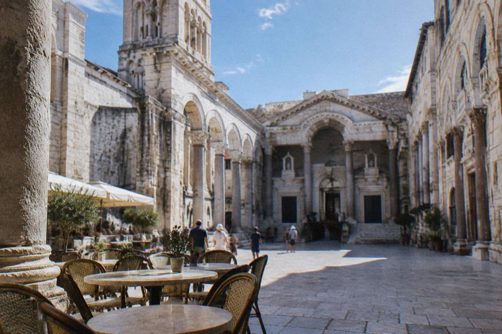 Peristyle square of Diocletian's Palace with stone columns and café tables