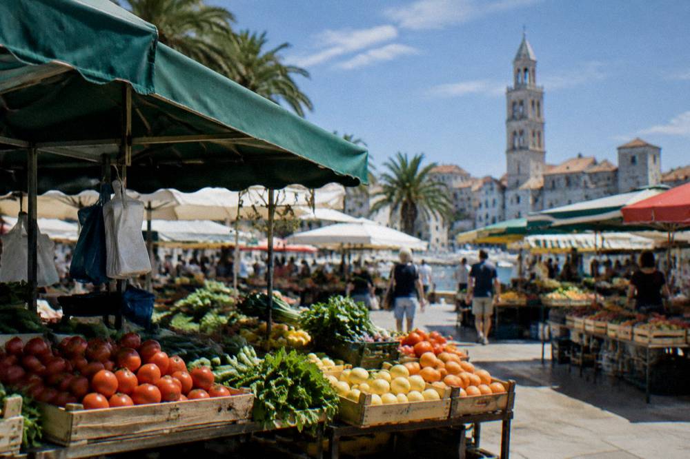 Market stalls with fruit and vegetables under awnings in Split green market