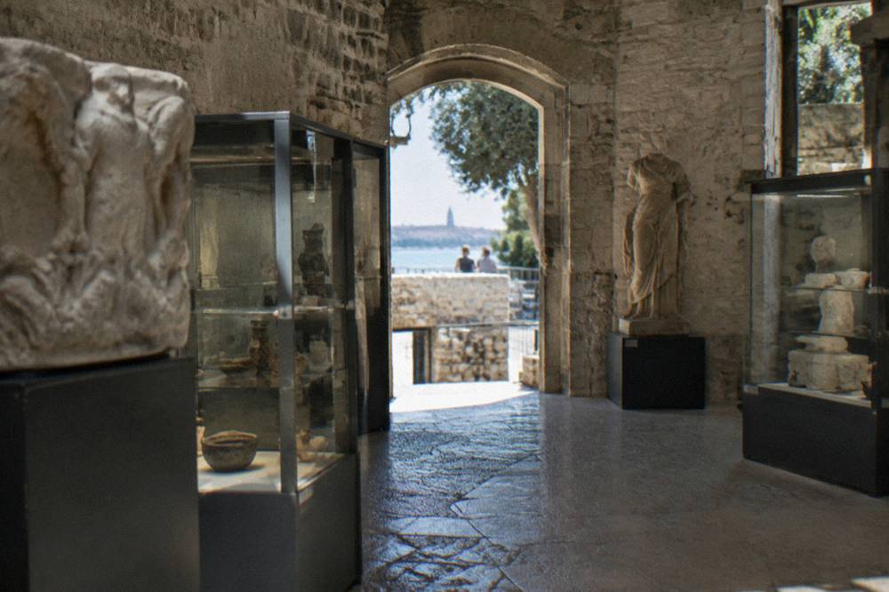 Display cases and stone walls inside the Split City Museum