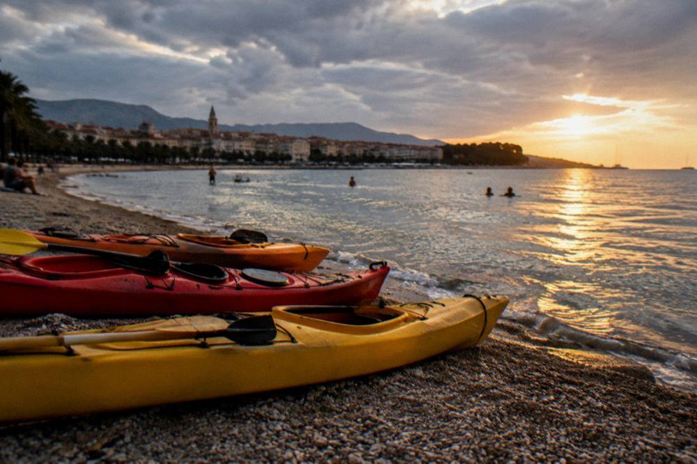 Kayaks on a pebble beach near Split under an overcast sky