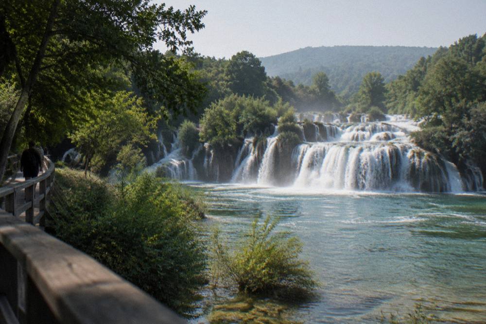 Waterfalls rushing through green forest at Krka National Park