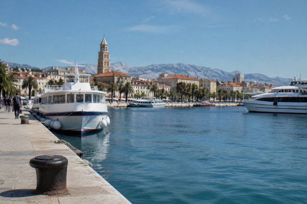 Ferry port quays in Split with passenger boats moored and the city behind