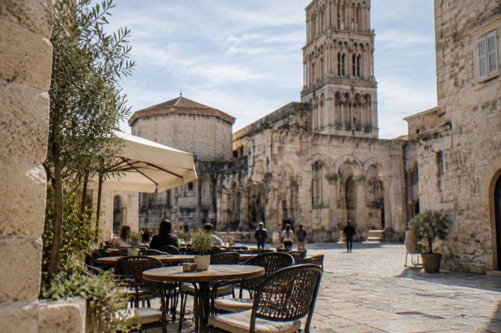 Outdoor café tables on a stone square in Split old town in sunshine