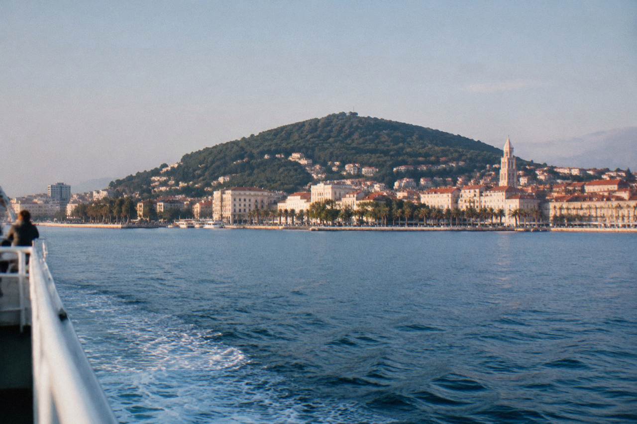 Ferry departing Split harbour with the Riva promenade and Marjan hill behind it