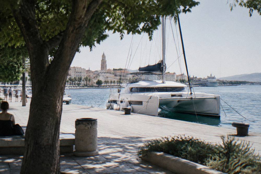 Catamaran moored at a Split quay in early morning light