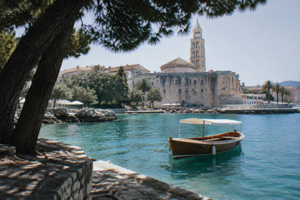 Wooden boat anchored in a turquoise cove between Dalmatian islands