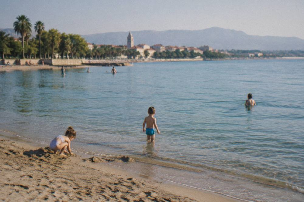 Children playing on the sandy beach at Bacvice with shallow clear water