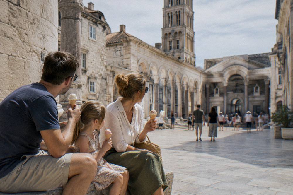 A family sharing ice cream on a sunny stone square in Split old town