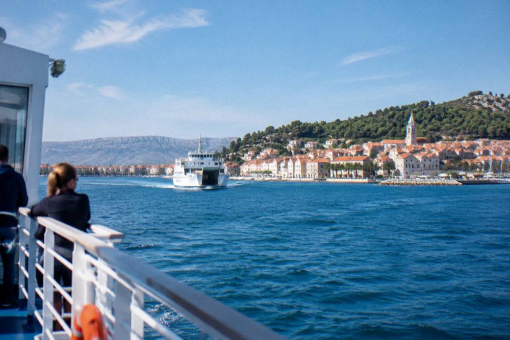 A ferry approaching an island town on the Adriatic seen from the deck