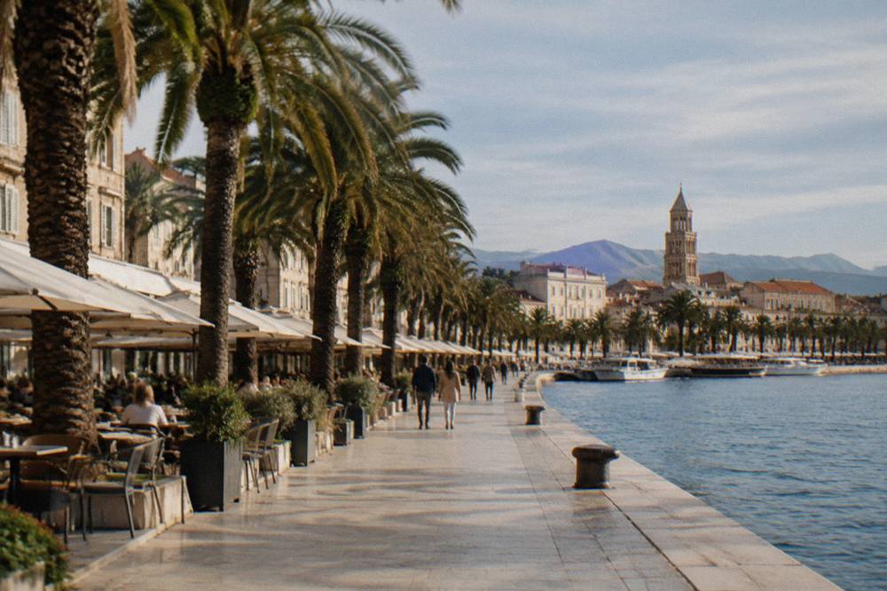 The seafront Riva promenade in Split lined with palm trees and cafe terraces facing the Adriatic