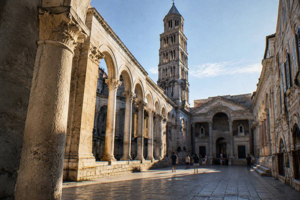 The ancient colonnaded Peristyle courtyard in Split with stone arches and the cathedral bell tower behind
