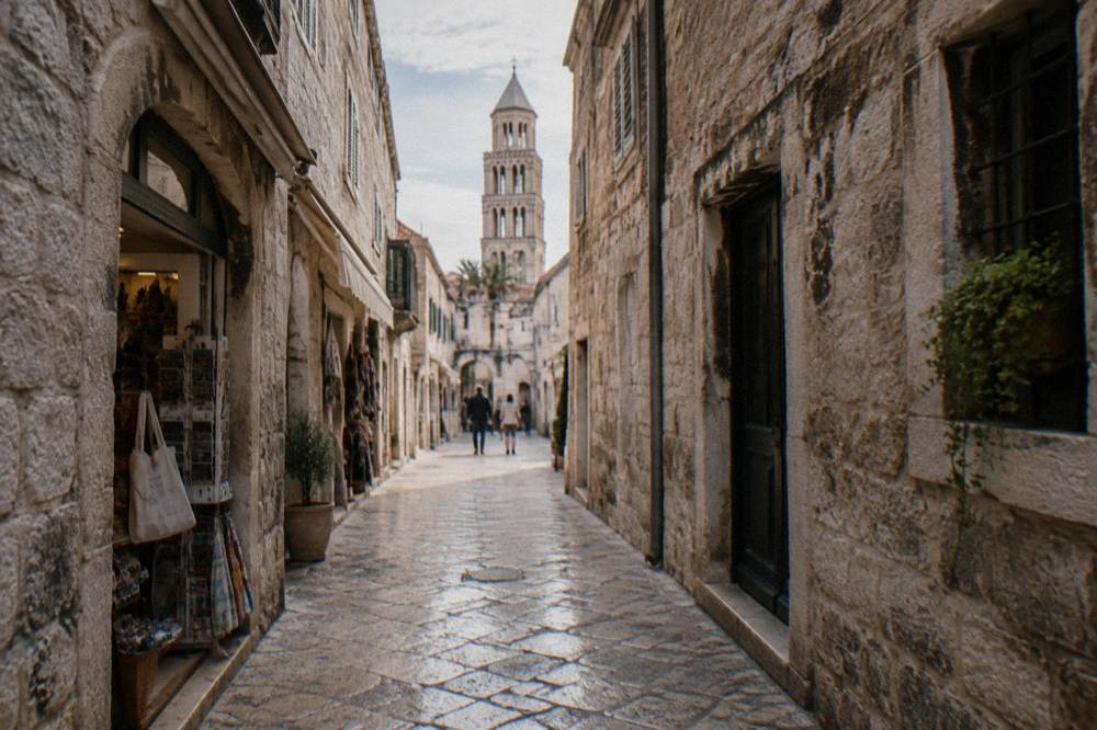 A narrow stone street inside the Old Town of Split with small shops and worn Roman paving