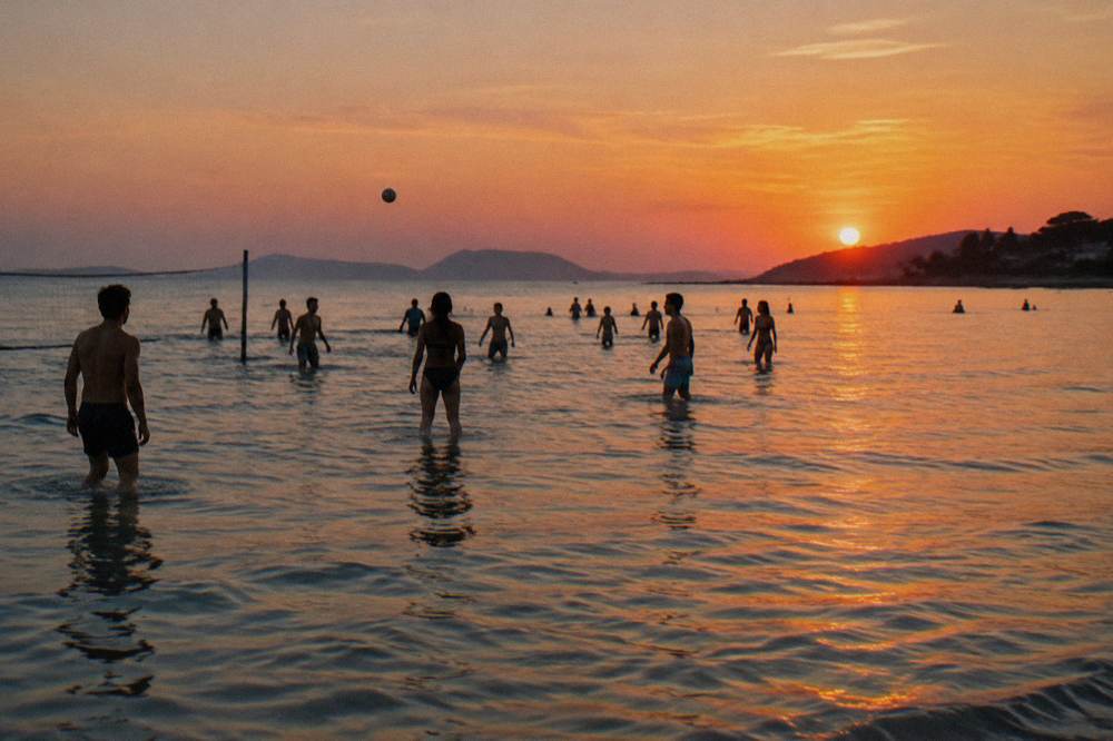Shallow sandy shallows at Bačvice beach with players standing in knee-deep water at sunset