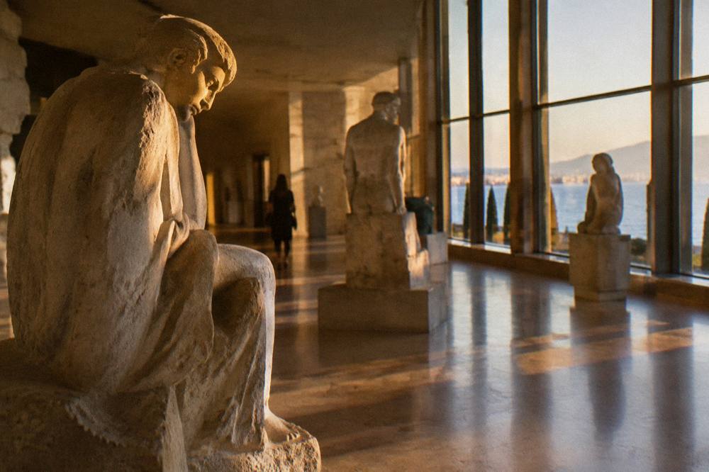 Sculpture gallery interior with stone figures lit by tall windows at the Mestrovic Gallery
